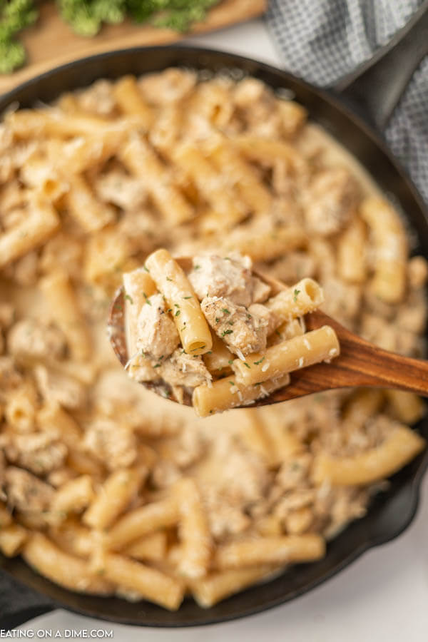 Spicy Creamy Chicken Pasta with a serving on a wooden spoon