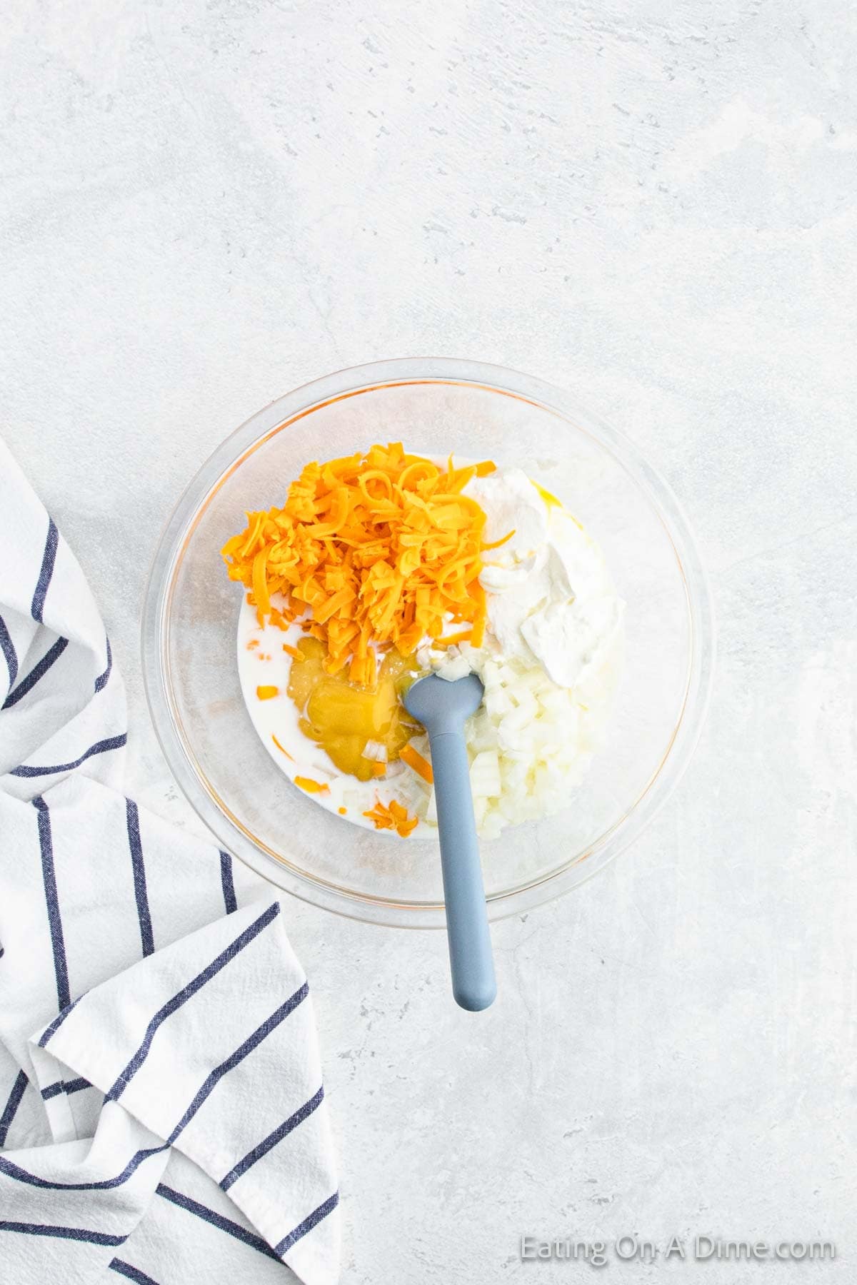 Combining the onion, cheese, milk, cream of chicken and sour cream in a bowl