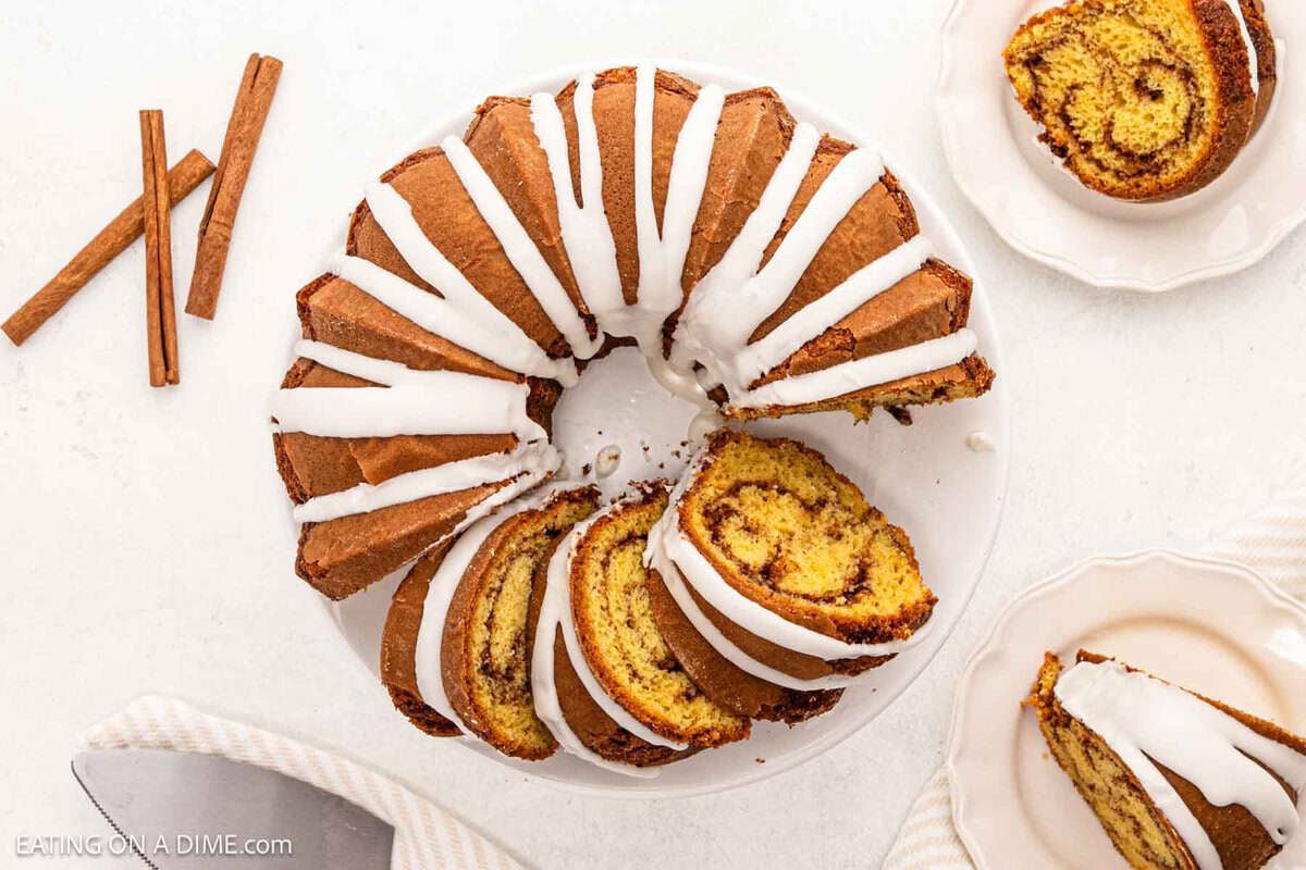 Cinnamon bundt cake topped with icing on a cake pan.