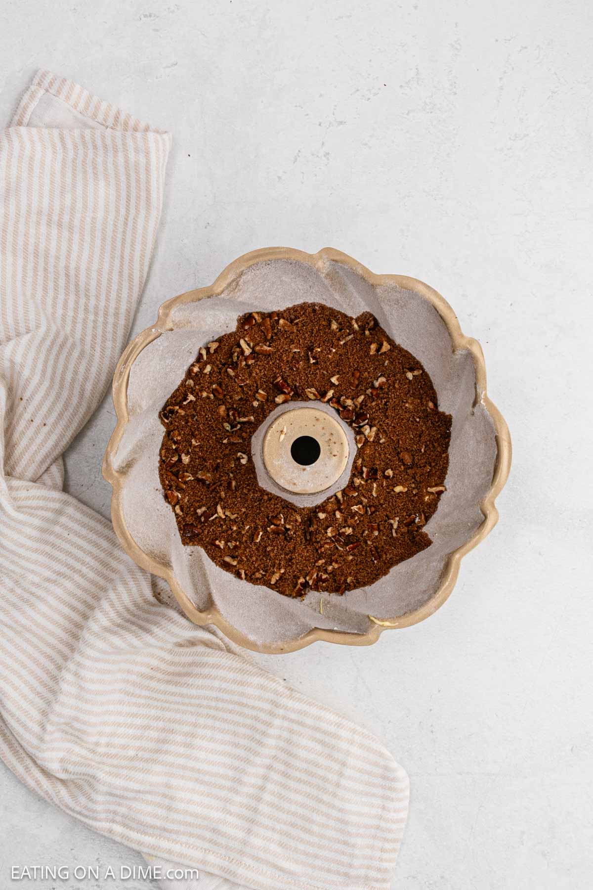 A portion of the sugar and nuts mixture in the bundt pan.