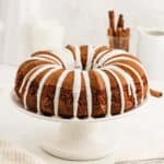 Cinnamon bundt cake topped with a icing on a cake pan.