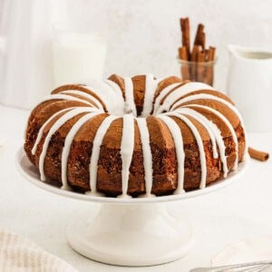 Cinnamon bundt cake topped with a icing on a cake pan.