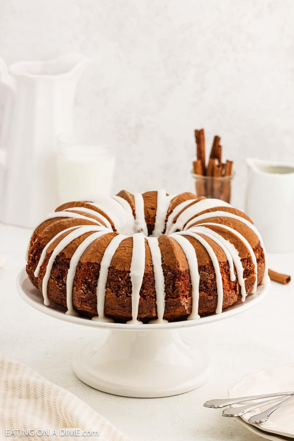 Iced cinnamon cake on a cake pan.