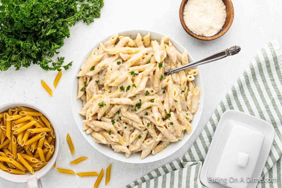 White Pasta Sauce over penne noodles in a large bowl