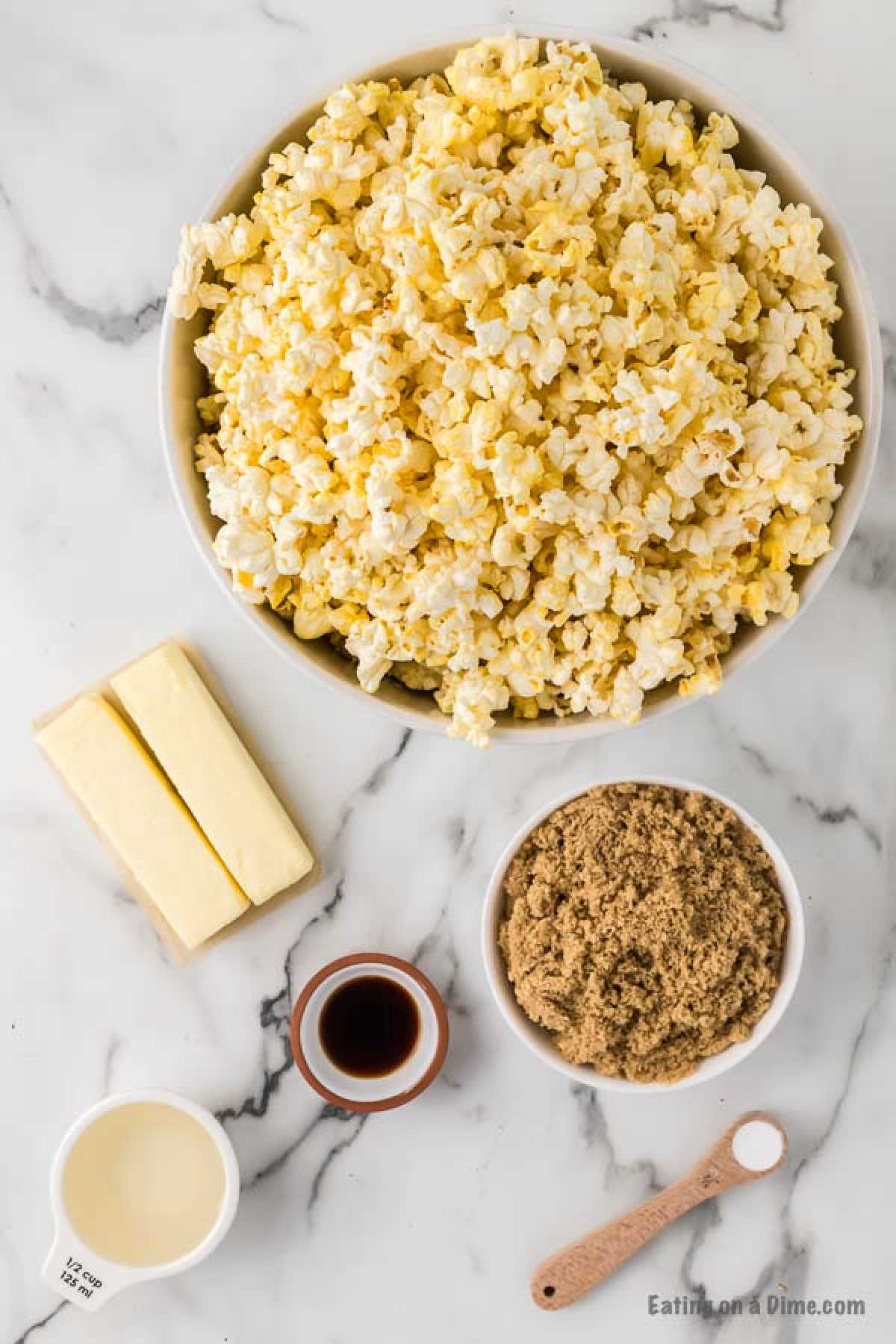 Close up image of ingredients for caramel popcorn - popcorn, butter, brown sugar, corn syrup, salt, baking soda, vanilla extract, butter
