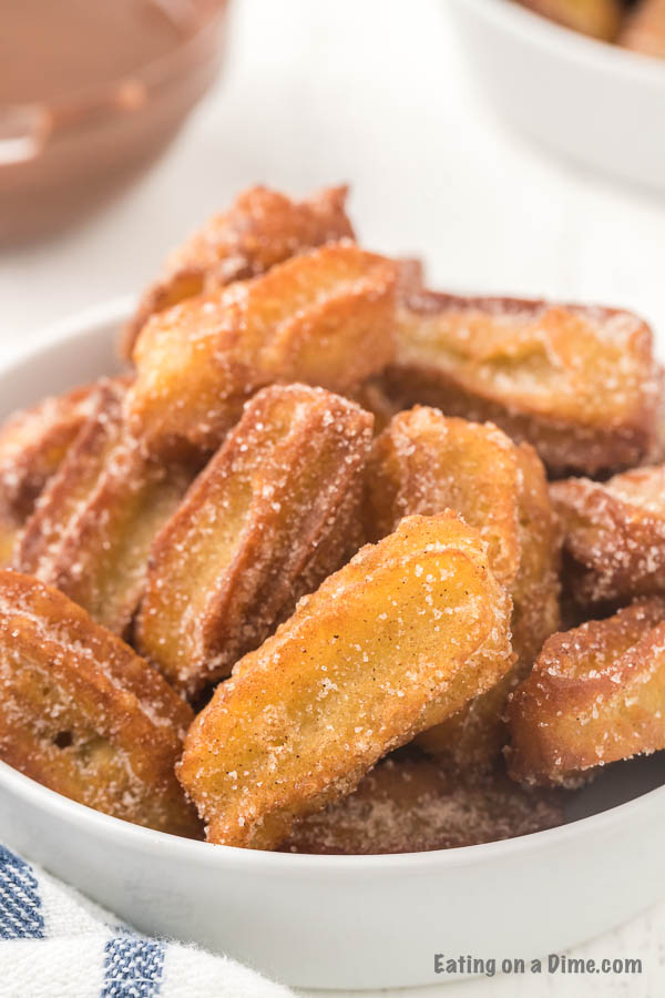 close up image of churros in a white bowl. 
