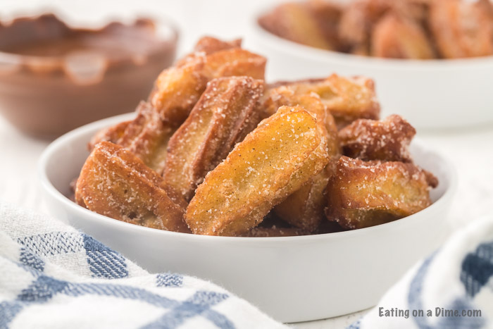 close up image of churros in a white bowl. 