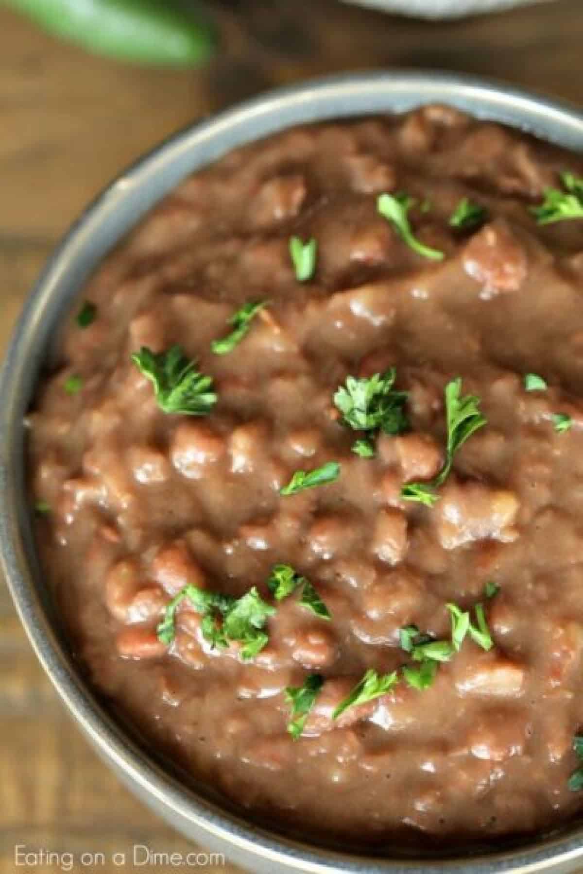 Learn how to make refried beans by cooking them in the crockpot! It is so easy to make Crock Pot refried beans and saves a ton of money.