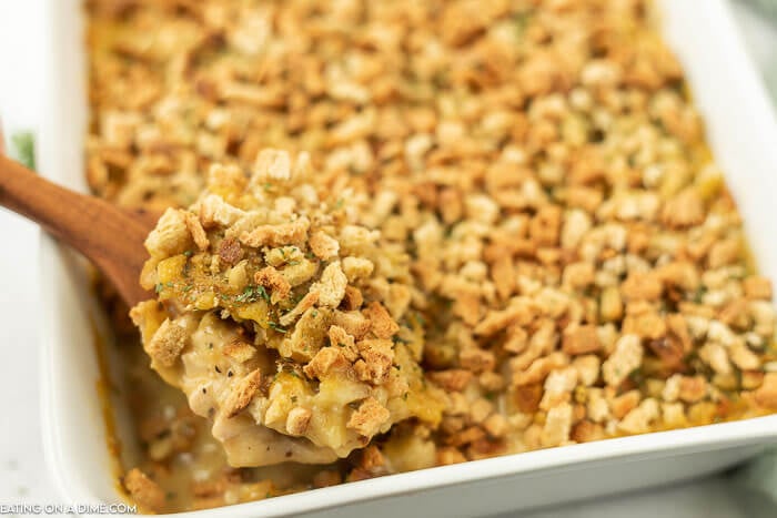 Chicken stuffing bake in casserole dish with a spoon. 