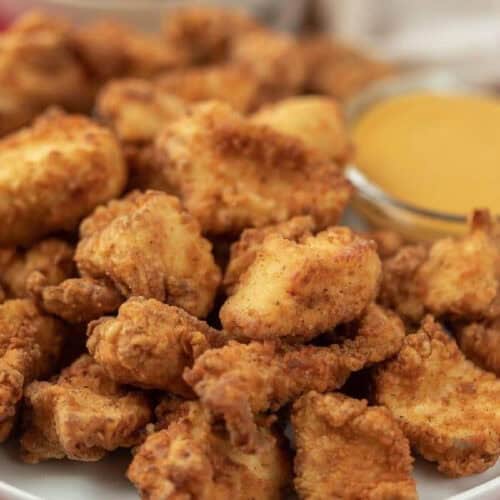 Chick-fil-A nuggets on a plate with a small bowl of dipping sauce.