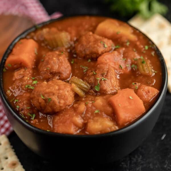 A black bowl of meatball stew.