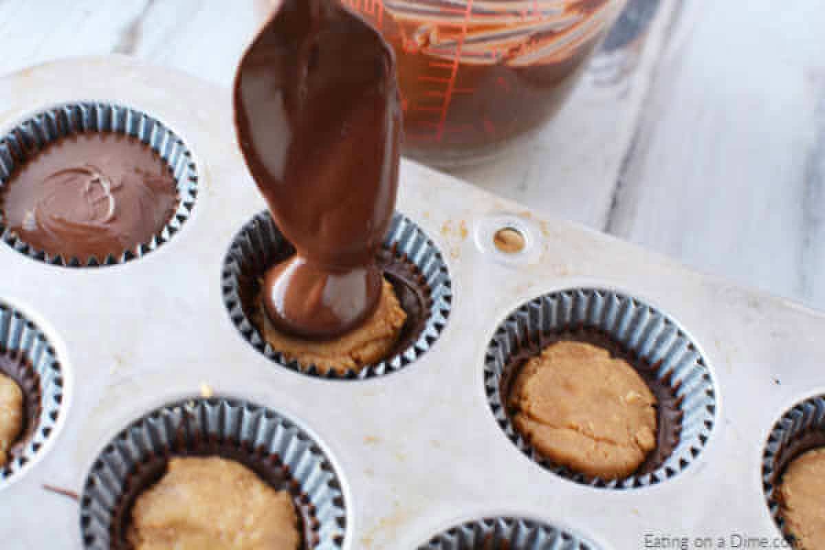 Chocolate being spooned over the peanut butter.