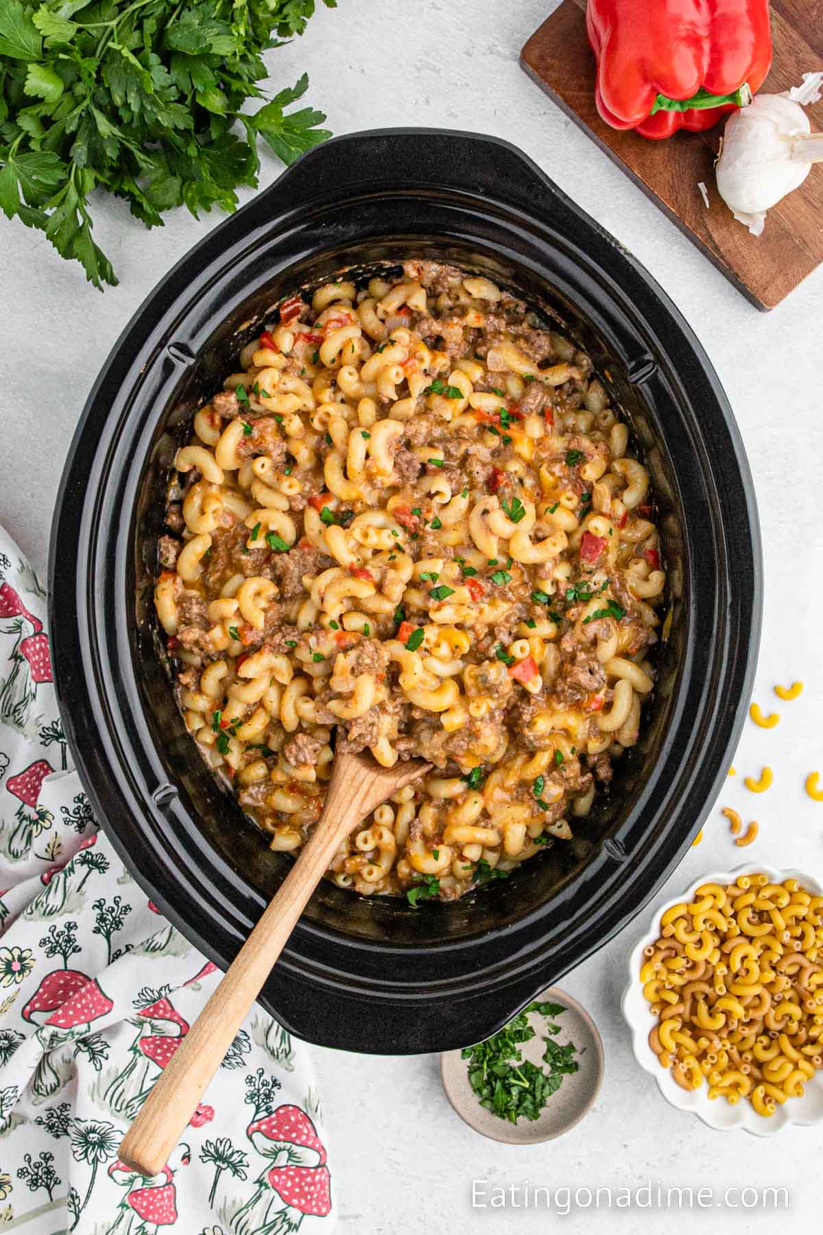 Hamburger helper in the slow cooker with a wooden spoon