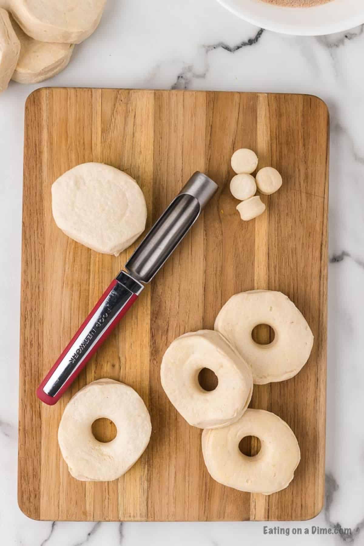 An apple corer inserted in the center of the biscuit dough to cut a hole in the center.