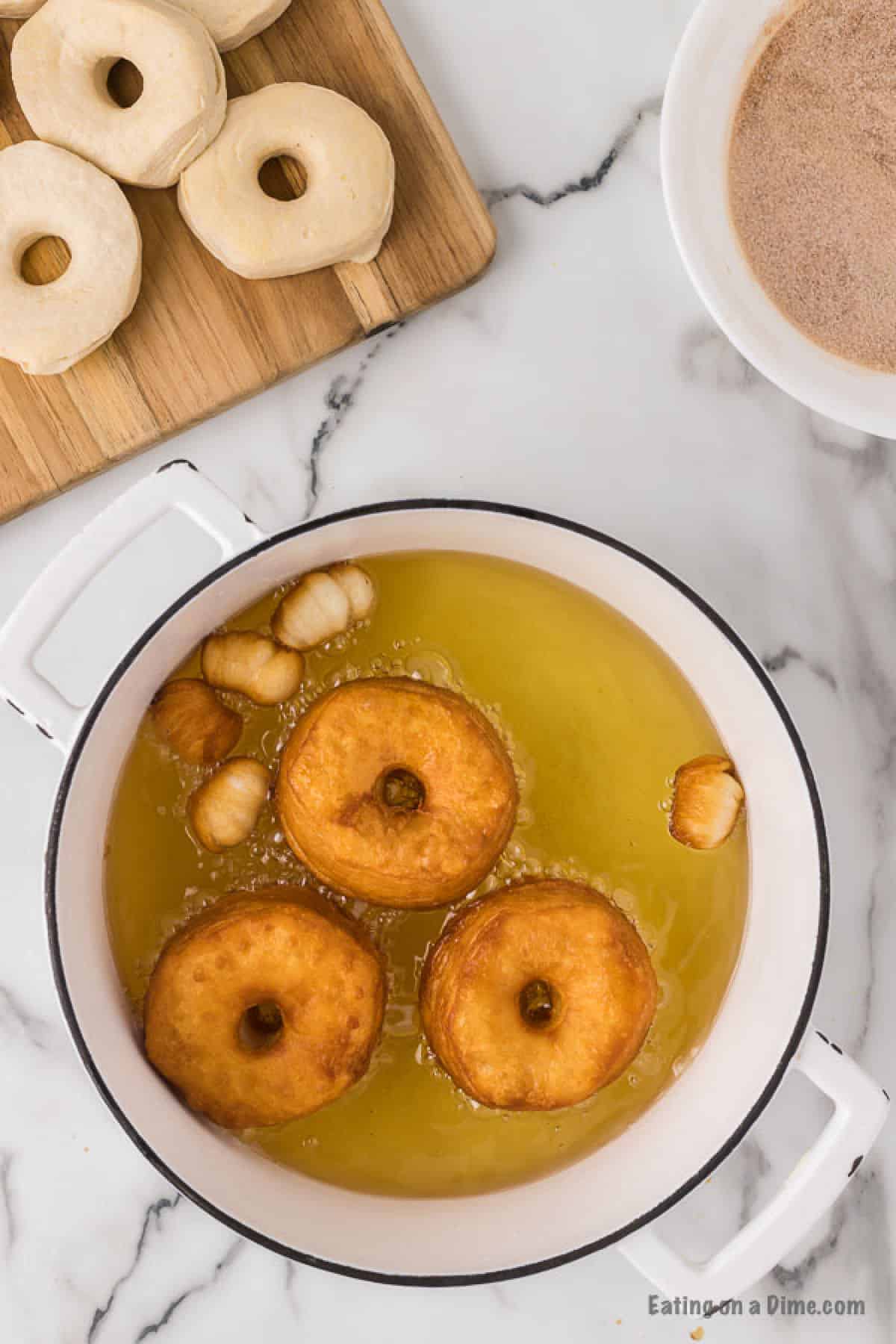 Donuts in a large pot with oil.