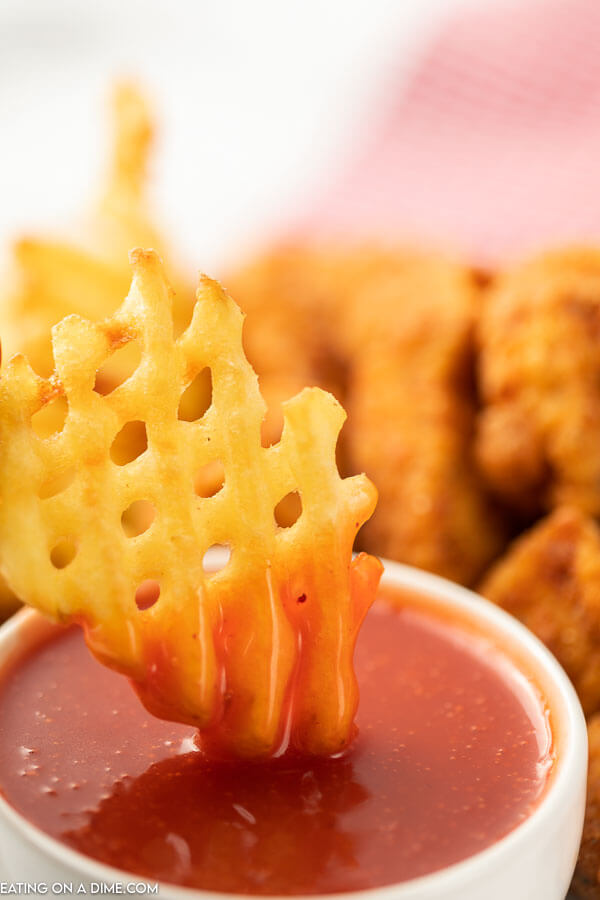 Close up image of polynesian sauce with a side of fries and chicken nuggets