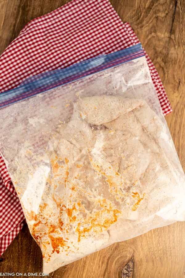 Chicken in ziploc bag with flour mixture.