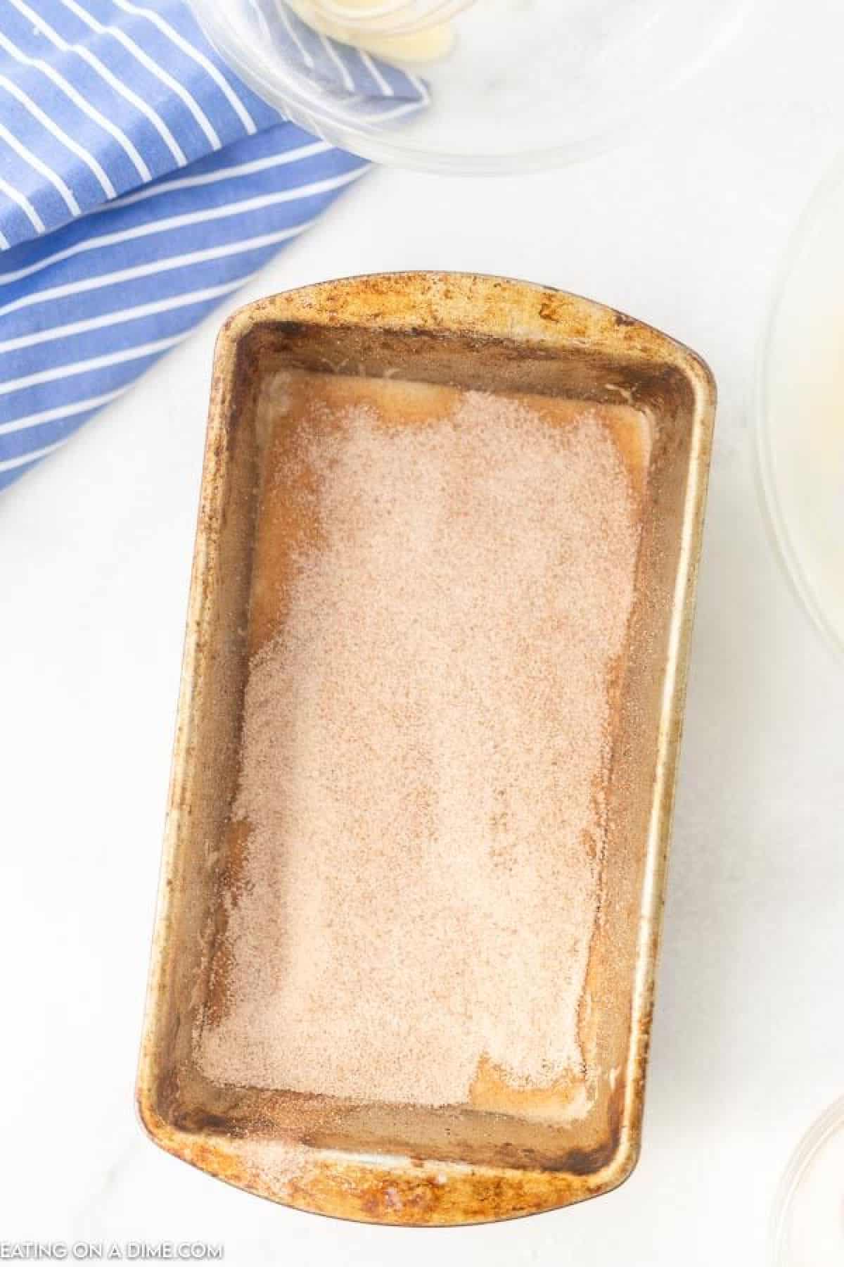 The process of adding the cinnamon mixture in the pan with the bread batter.