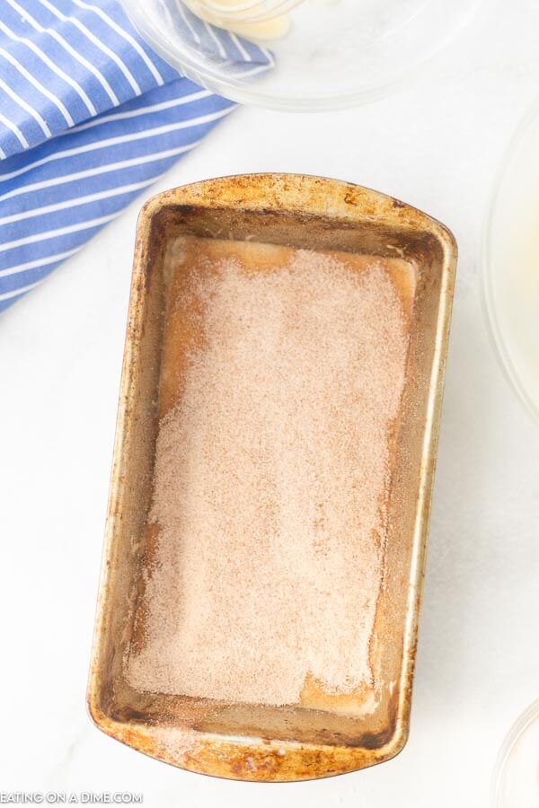 The process of adding the cinnamon mixture in the pan with the bread batter. 