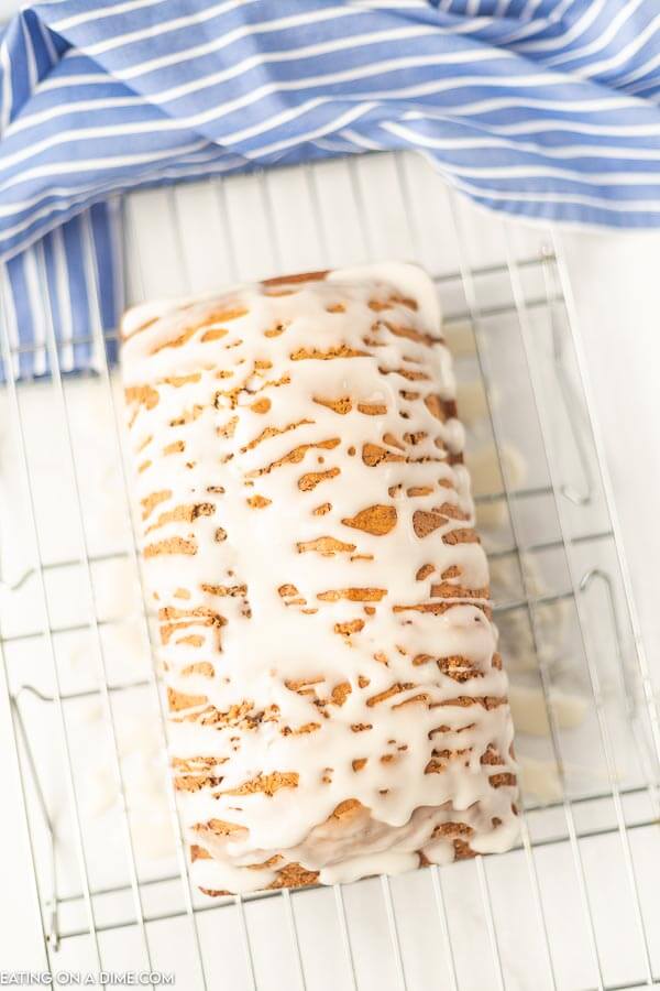 Close up image of cinnamon swirl bread with glaze on top resting on a cooling rack. 