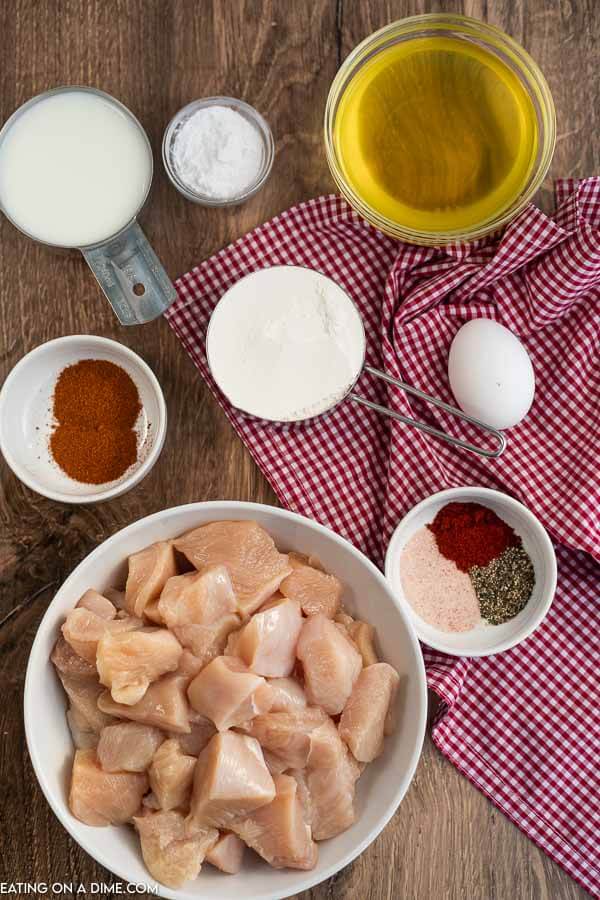 Ingredients needed for spicy chicken nuggets - chicken breast, pickle juice, egg, milk, flour, powdered sugar, paprika, cayenne pepper, pepper and salt, peanut oil. 