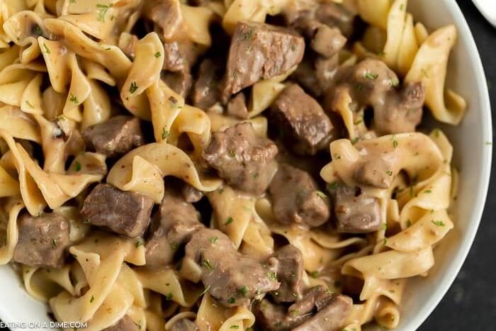 Close up image of a bowl of beef burgundy over noodles. 