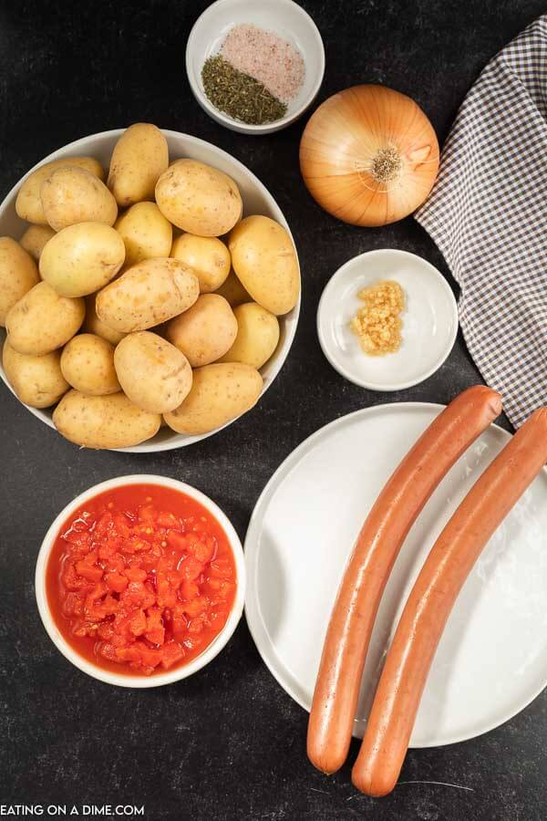 Ingredients to make crock pot sausage and potatoes: Sausage, baby potatoes, onion, minced garlic, diced tomatoes, salt and pepper 