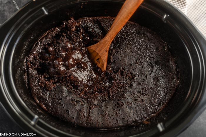 Close up image of chocolate lava cake with a wooden spoon. 