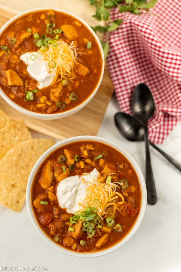 2 bowls of this Tex Mex Chicken Chili with tortilla chips next to them and 2 spoons 