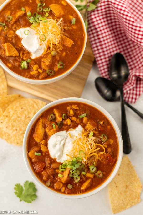 2 bowls of this Tex Mex Chicken Chili with tortilla chips next to them and 2 spoons 