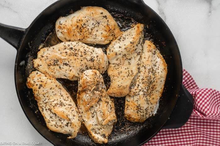 Close up image of cooking chicken in an iron skillet