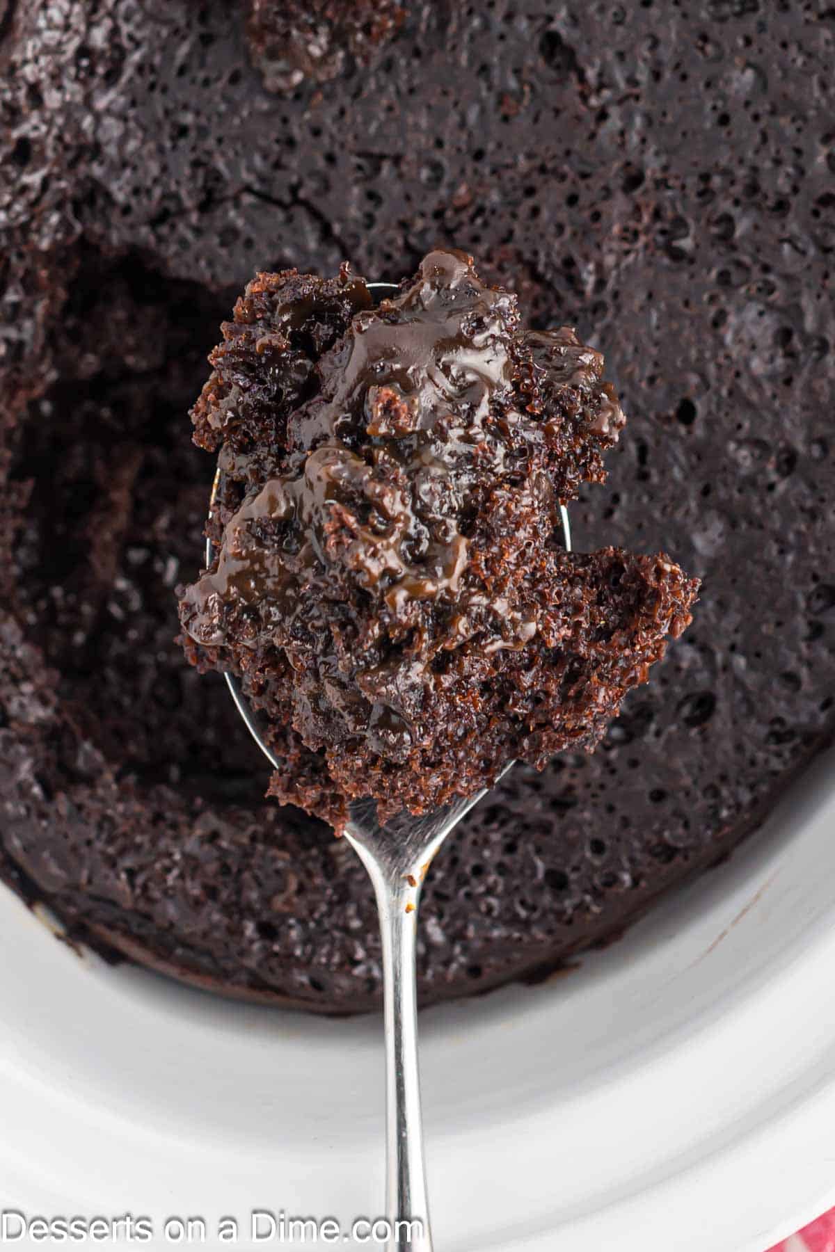 Close up image of chocolate lava cake in slow cooker with a serving on a spoon