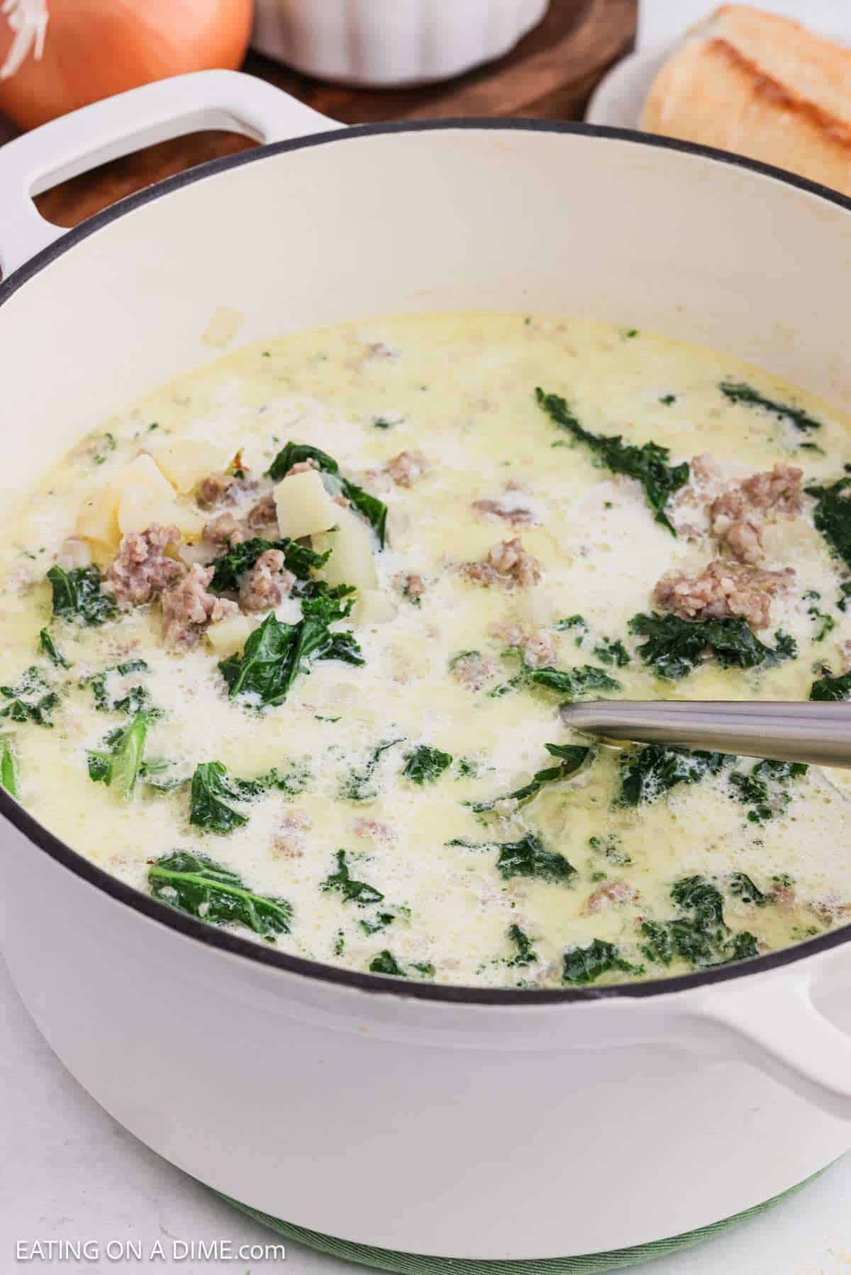 Creamy soup with kale, potatoes and sausage in a large pot.