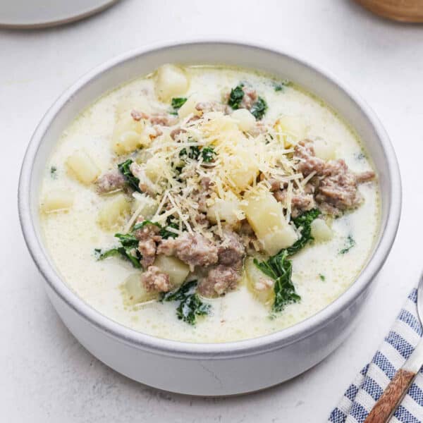 Bowl of Zuppa Toscana Soup topped with shredded parmesan cheese.