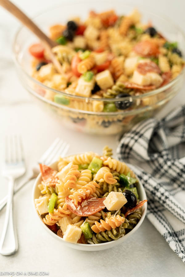 Close up image of Italian Pasta Salad in a clear bowl with a small serving in a white bowl. 
