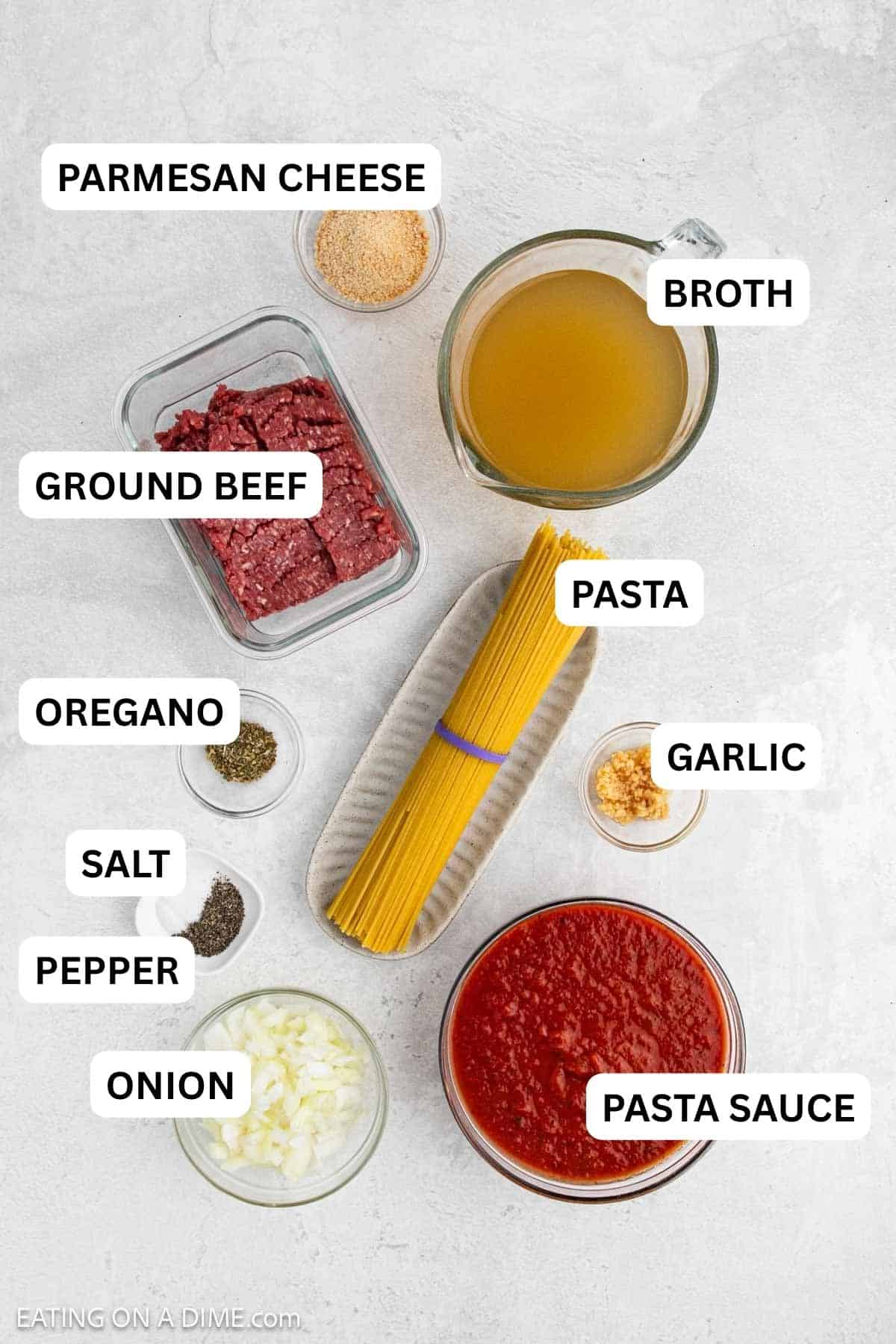 Ingredients needed to make this recipe which includes ground beef, onion, garlic, pasta sauce, oregano, salt and pepper, chicken broth, spaghetti noodles and parmesan cheese.