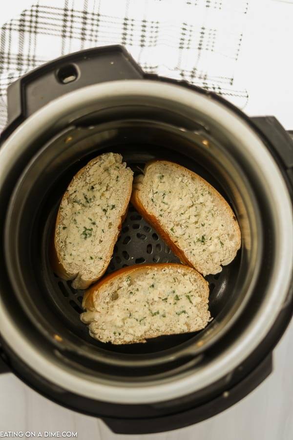 Bread with garlic butter in the air fryer basket. 