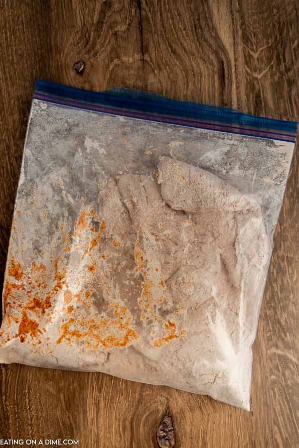 Close up image of chicken in a zip lock with ingredients. 