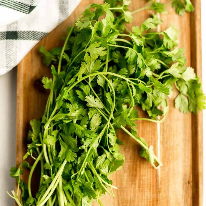 Close up image of cilantro on a cutting board. 