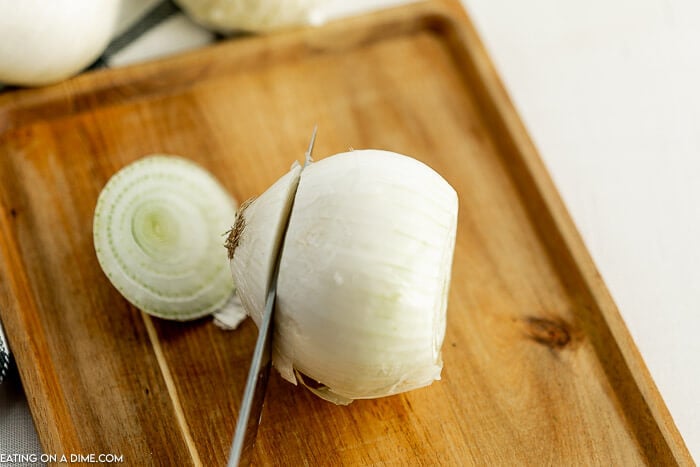 Close up image of cutting an onion on a cutting board. 