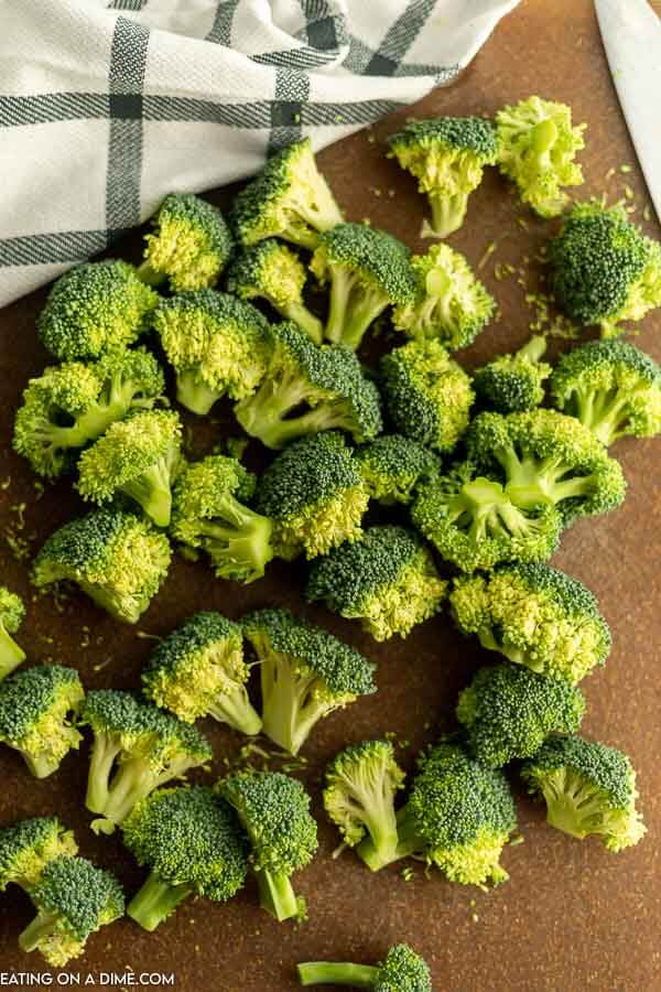 Close up image of cut broccoli on a cutting board. 