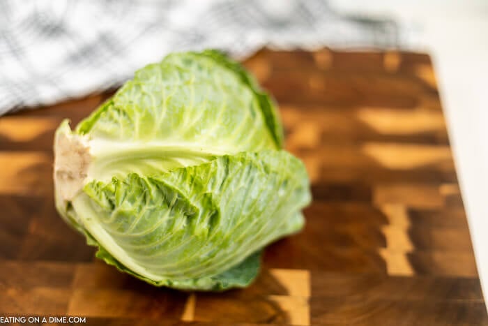Close up image of whole cabbage on a cutting board. 