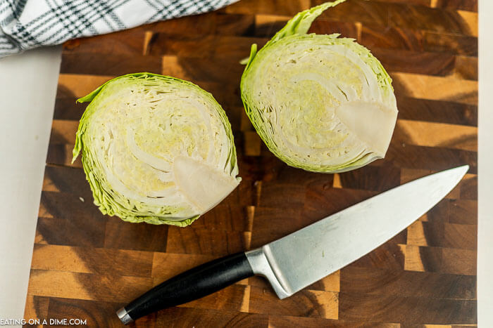 Close up image of sliced cabbage on a cutting board with a knife. 