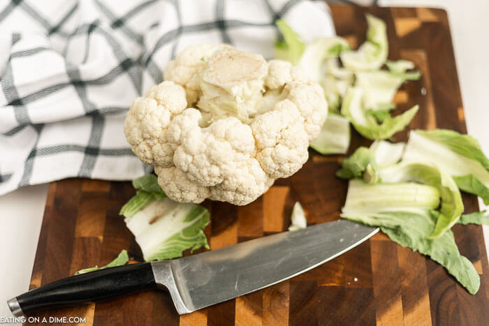 Cauliflower on a cutting board with a knife. 