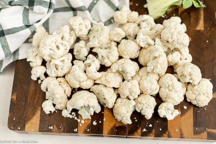 Close up image of a cauliflower florets on a cutting board. 