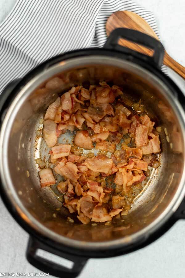 Close up image of bacon and onions being cooked in the instant pot. 