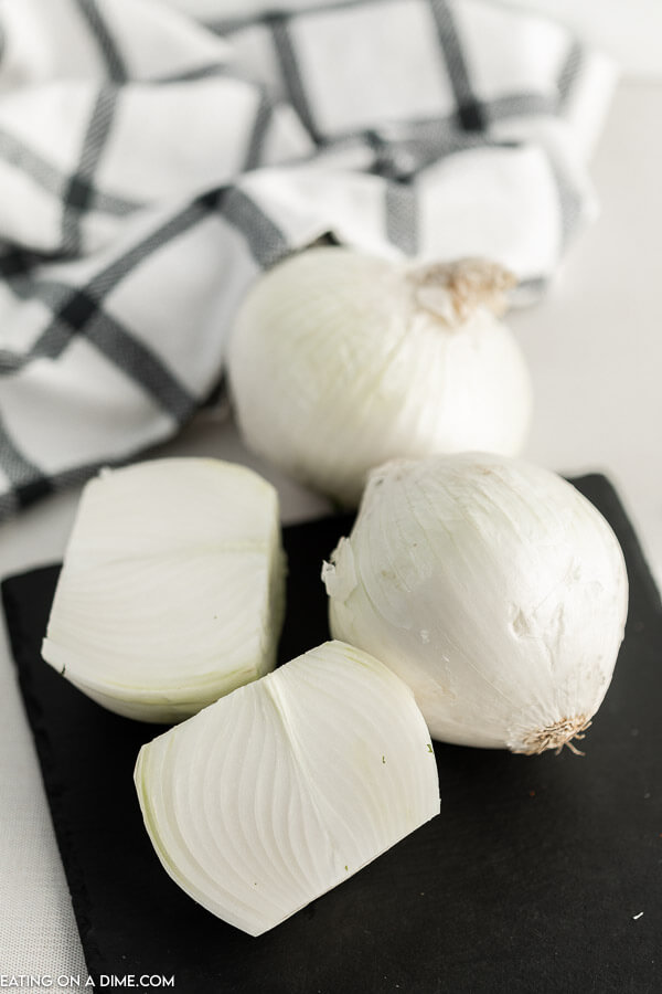 Close up image of whole onions on a cutting board.