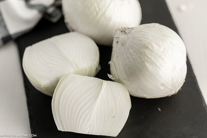 Close up image of whole onions on a cutting board.