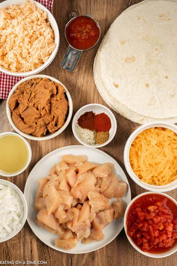Ingredients needed - chicken, onion, olive oil, garlic salt, chili powder, cumin, paprika, diced tomatoes, salsa, refried beans, tortillas, mexican rice, cheese. 