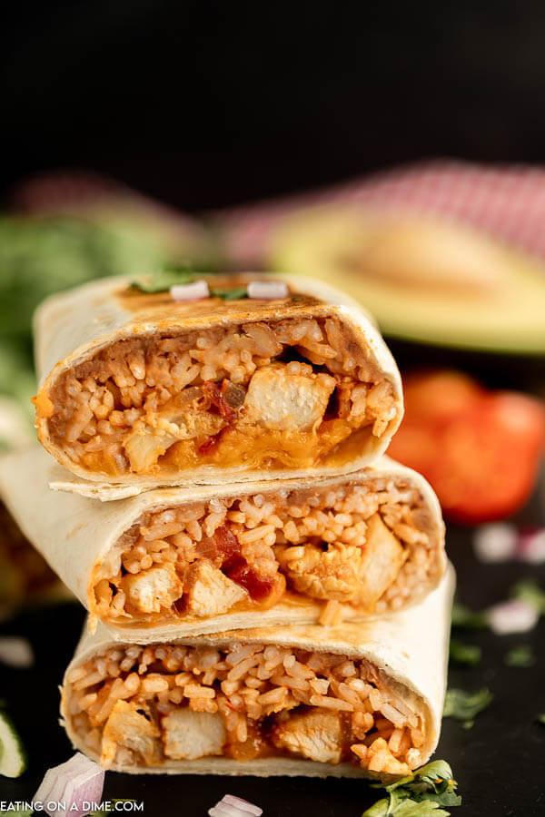 Close up image of chicken and rice burritos stacked. 